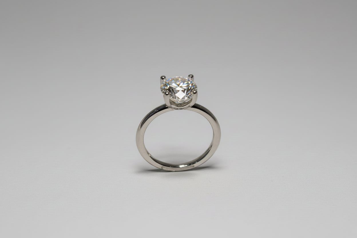 Silver ring with a diamond on a black background