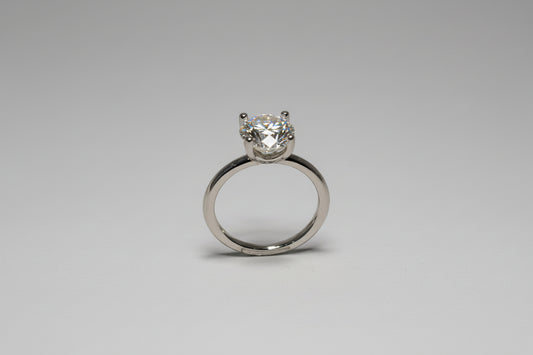 Silver ring with a diamond on a black background